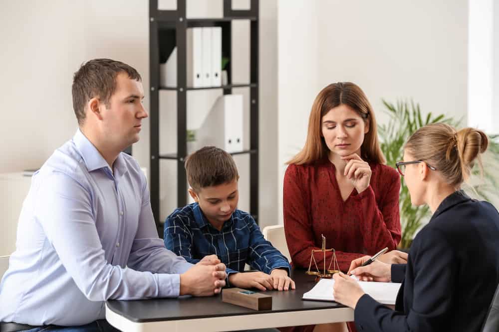 Divorced parents with their son visiting lawyer. Concept of child support